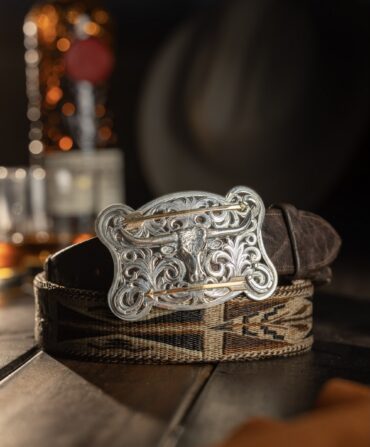 A silver belt buckle on a leather belt