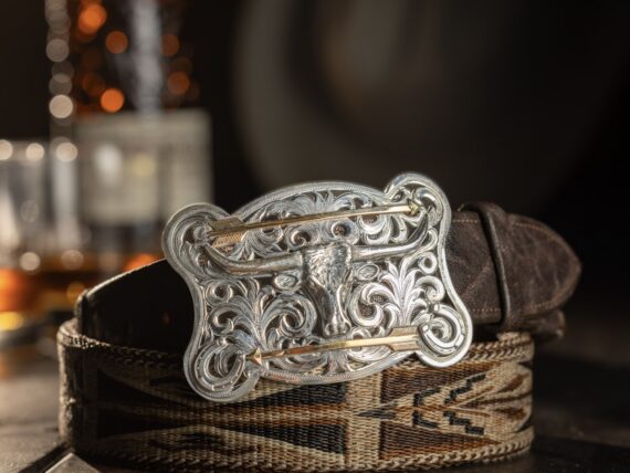 A silver belt buckle on a leather belt
