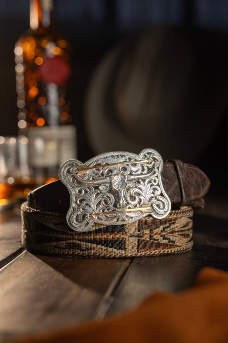 A silver belt buckle on a leather belt