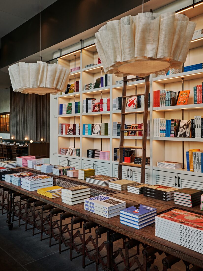 Inside a restaurant with a table of books and canvas pendants