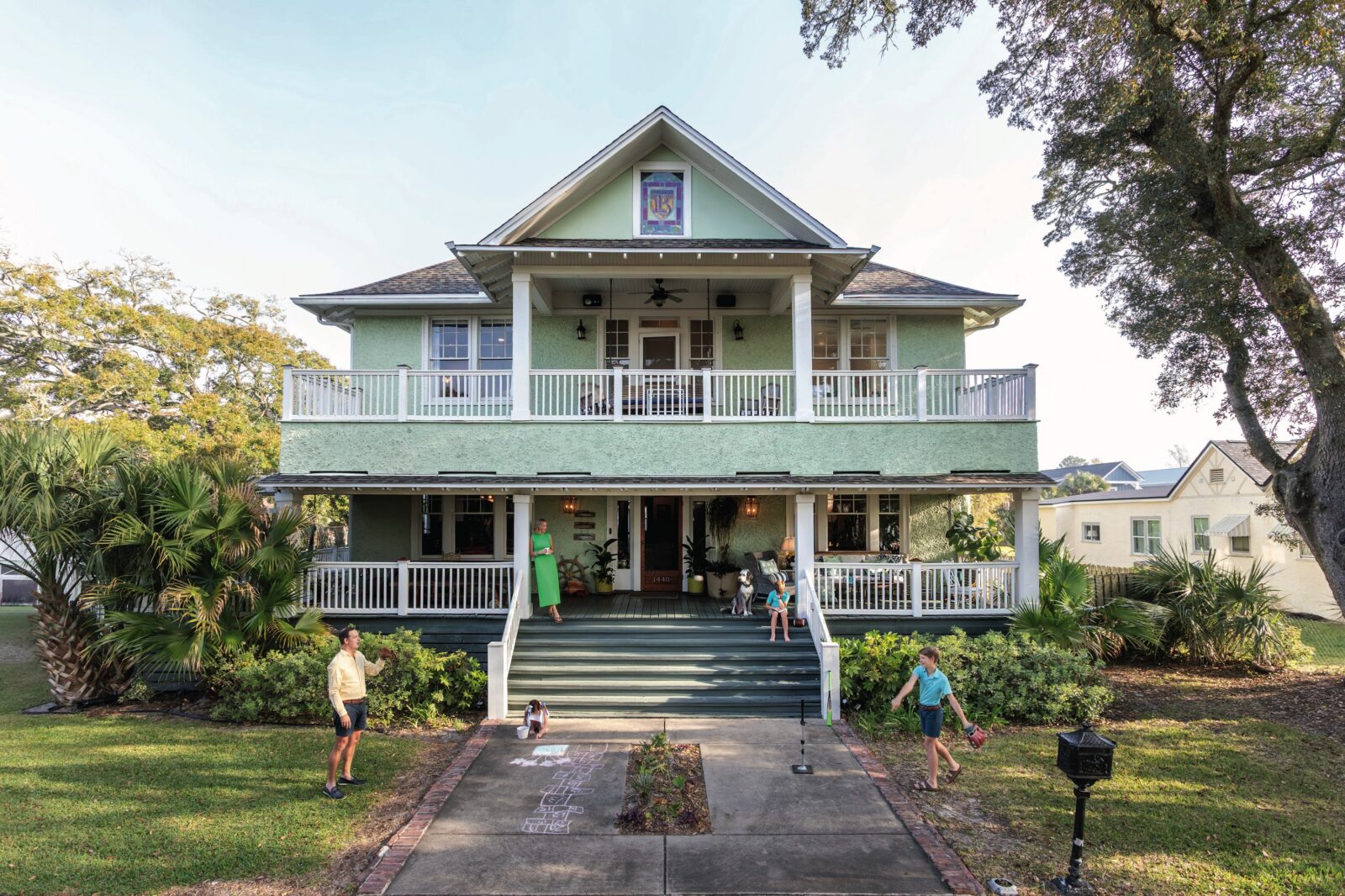 A green house with a family outside