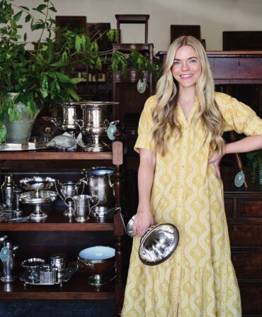 A woman holds silver in an antique store