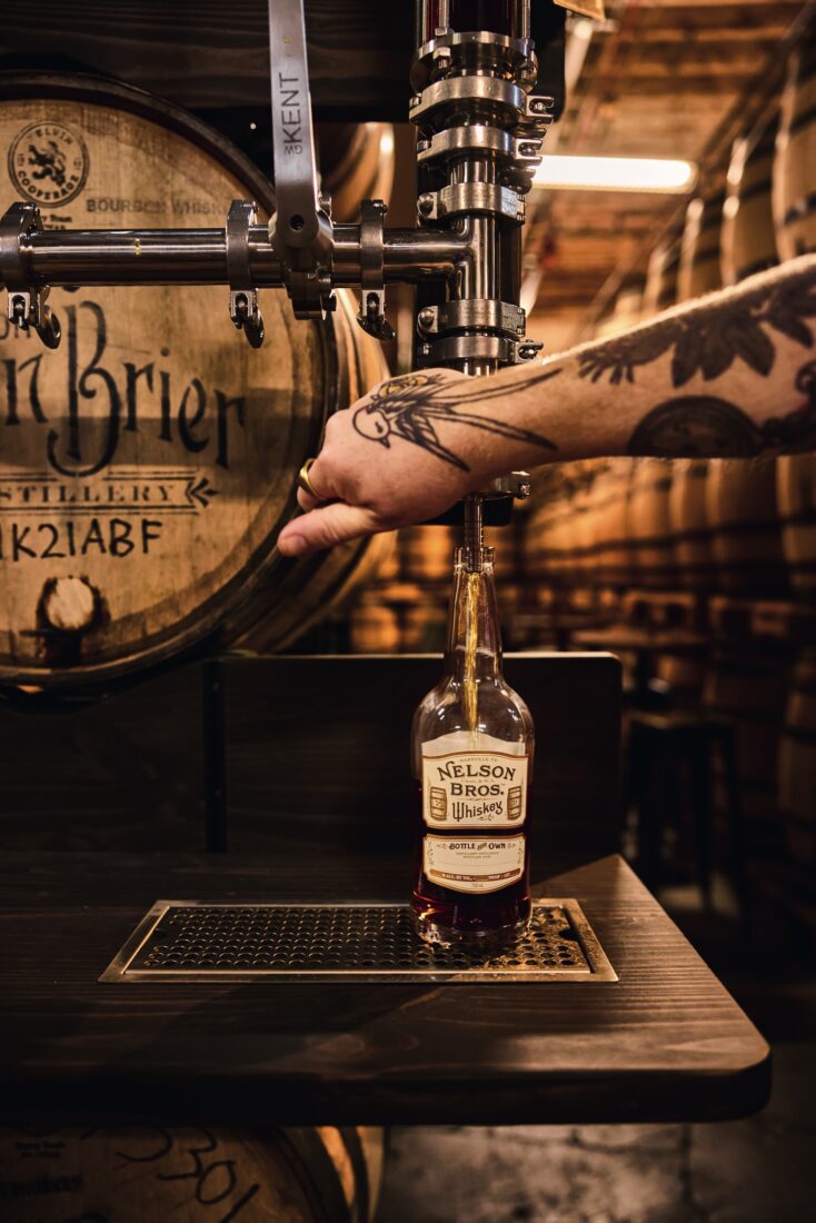 A person fills a whiskey bottle