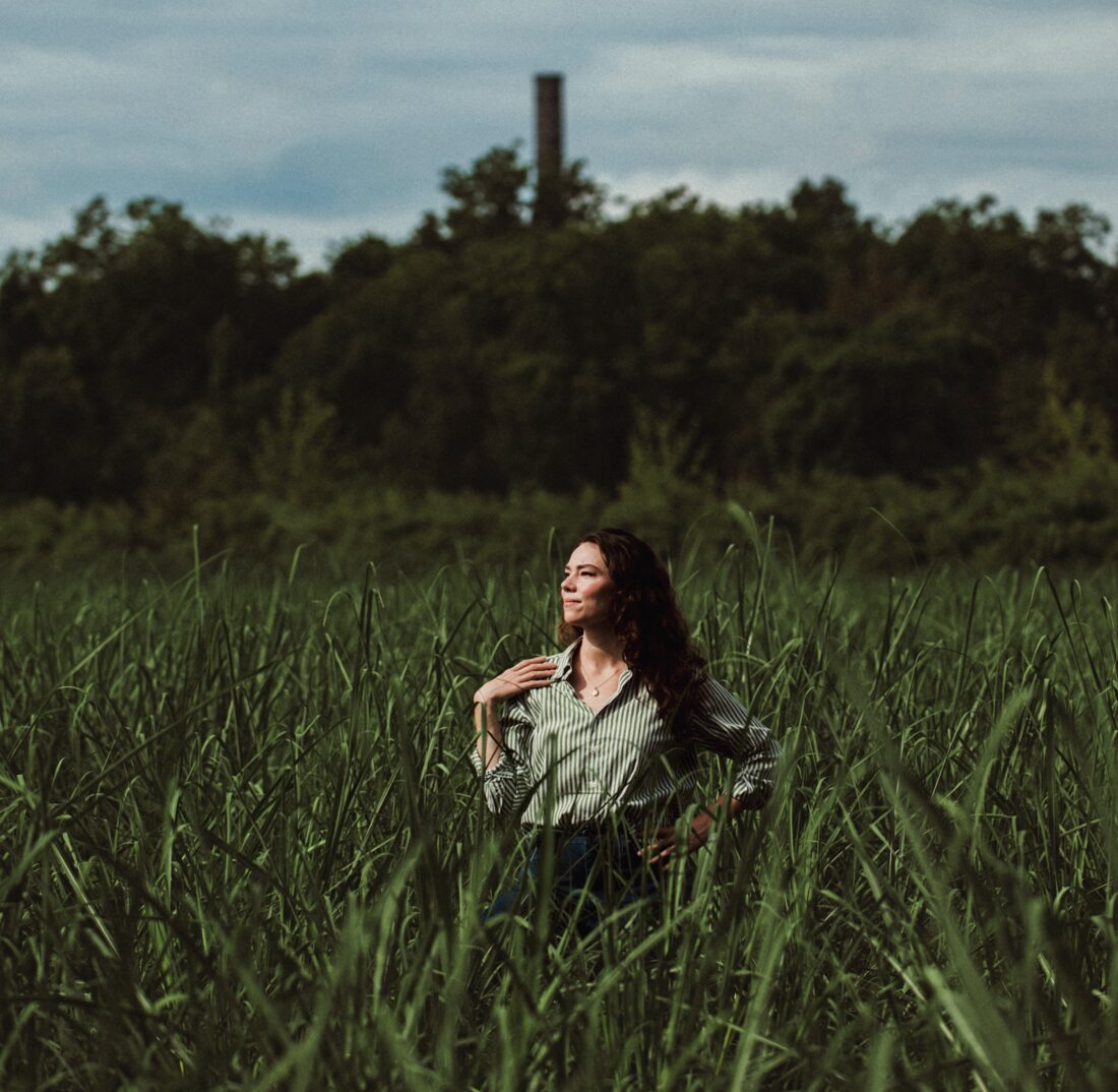 A woman stands in a sugar cane field