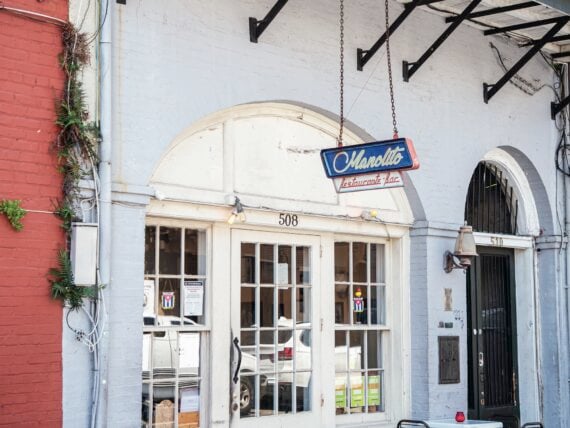 Outside a bar with red chairs and tables on the sidewalk