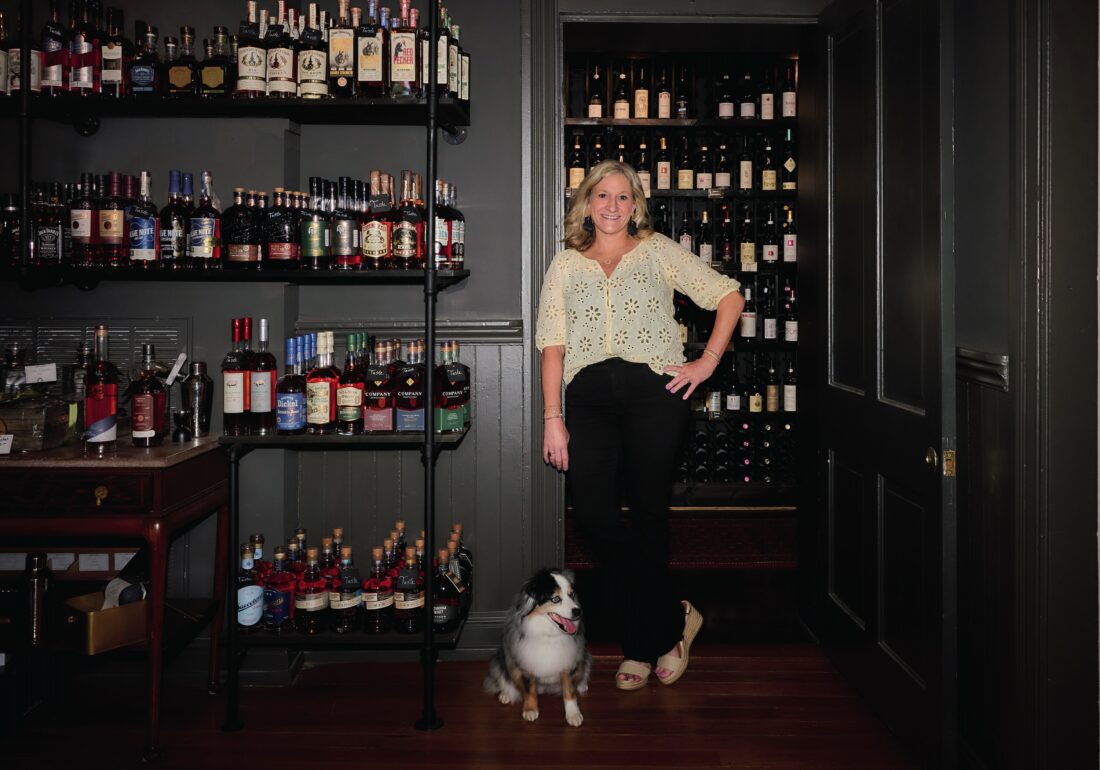 A woman in a bottle shop with a dog