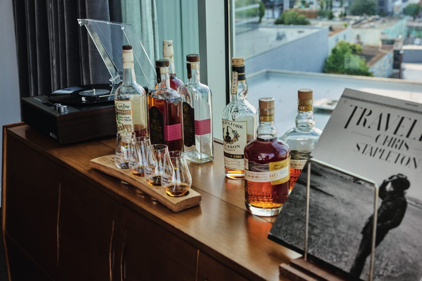 Bottles and a flight of whiskey on a table