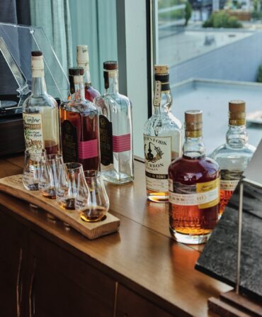 Bottles and a flight of whiskey on a table