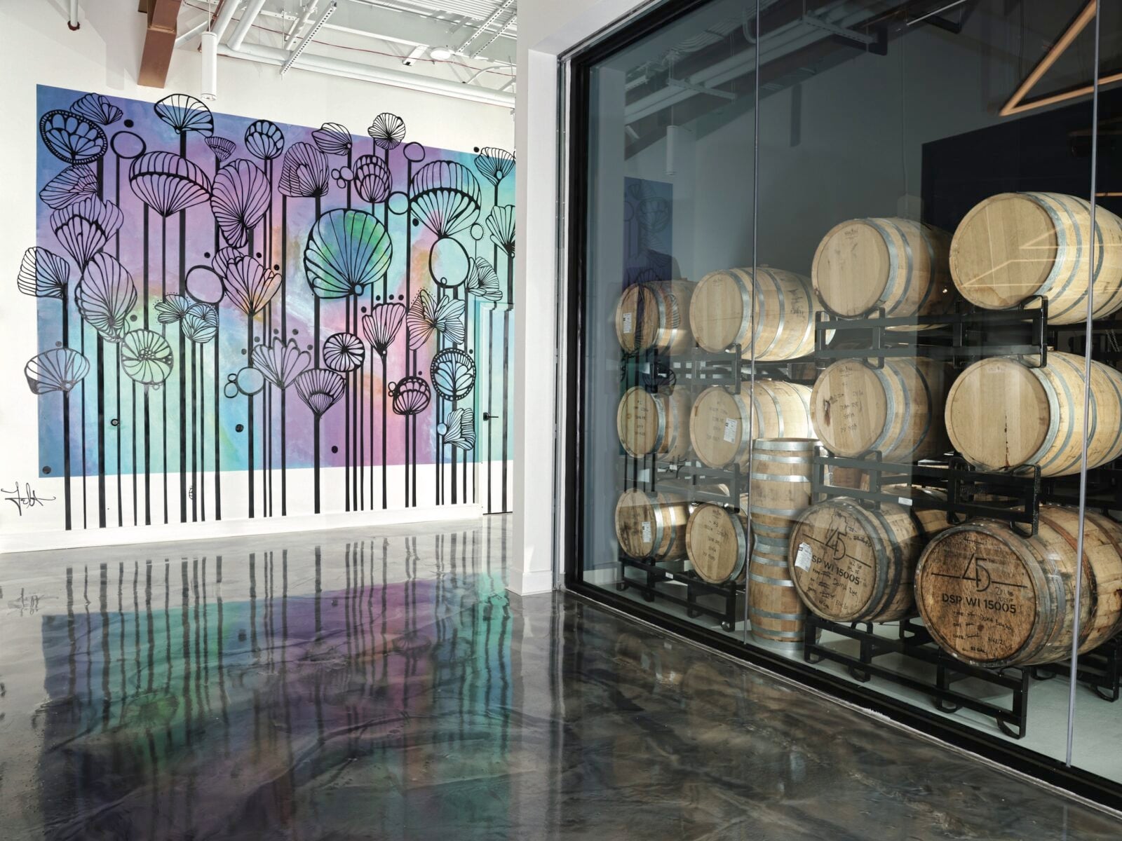 A distillery room with barrels and artwork