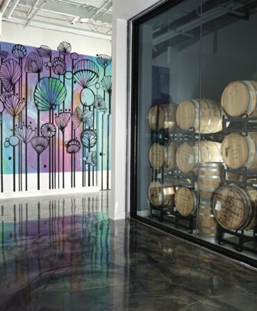 A distillery room with barrels and artwork