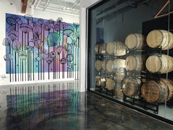 A distillery room with barrels and artwork