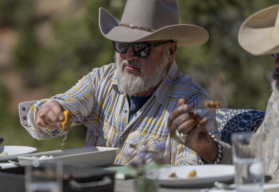 A man squeezes a lemon on food