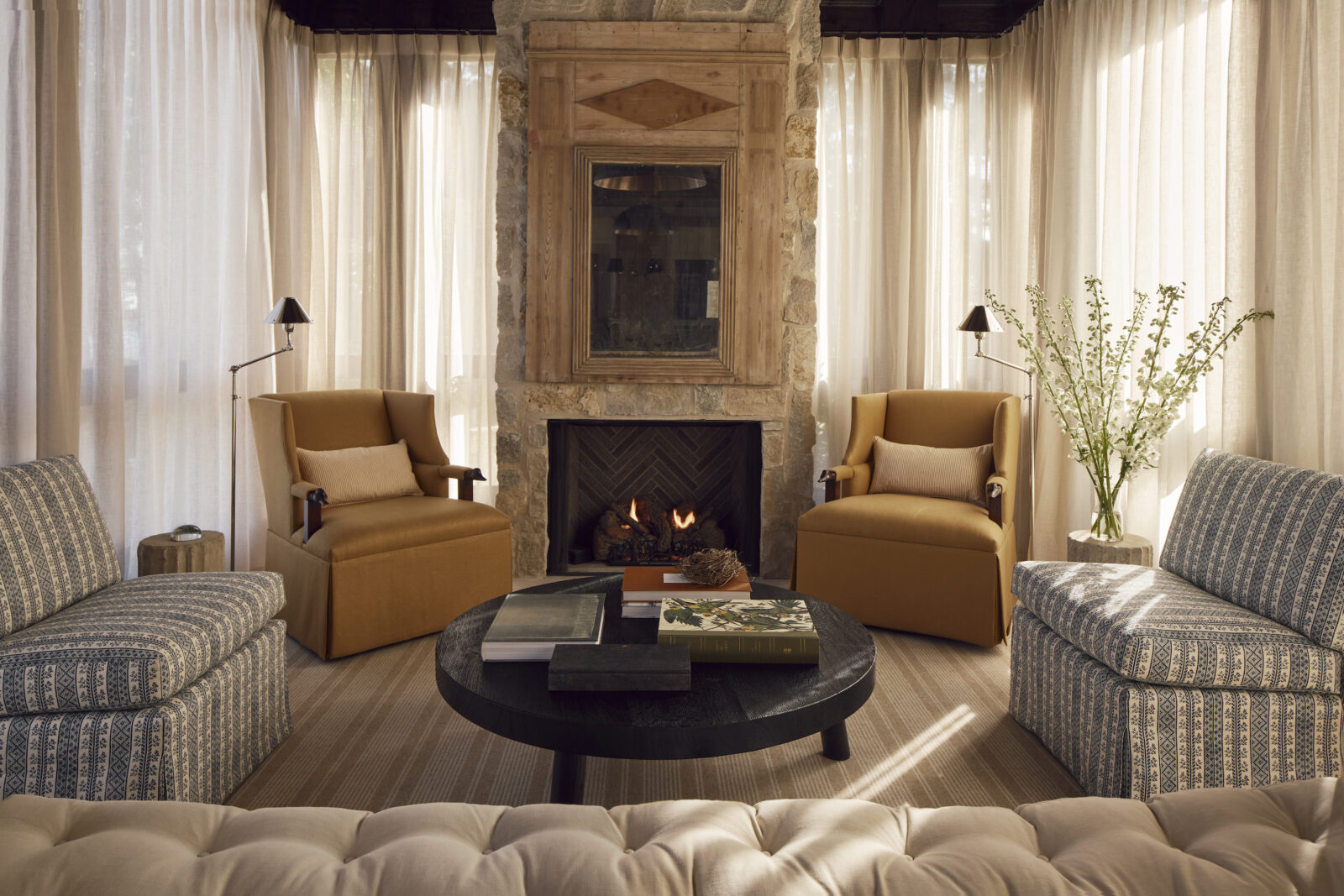 A living room with stone accents and tall windows