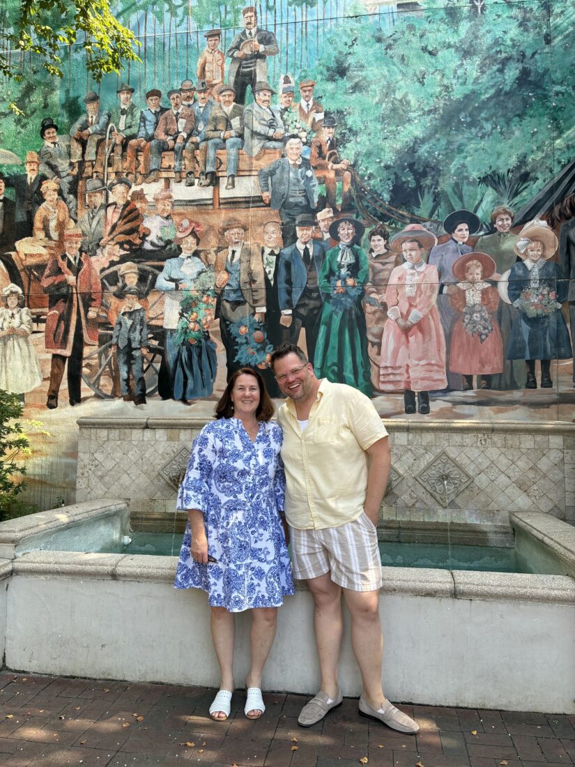 A man and woman in front of a mural