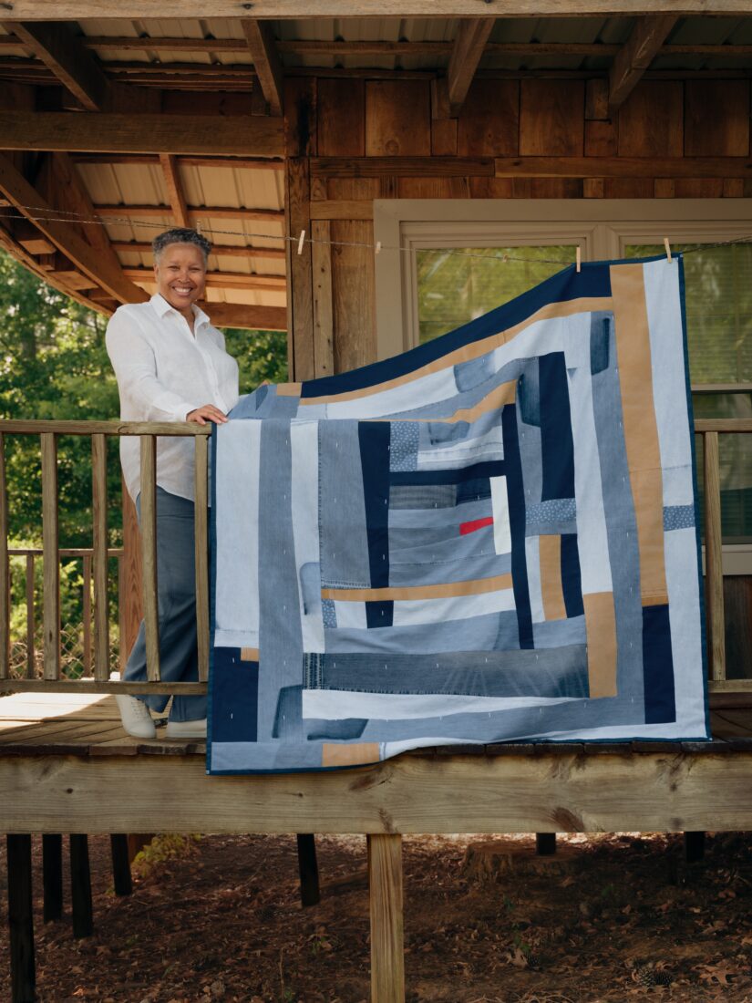 A woman with a quilt on a porch