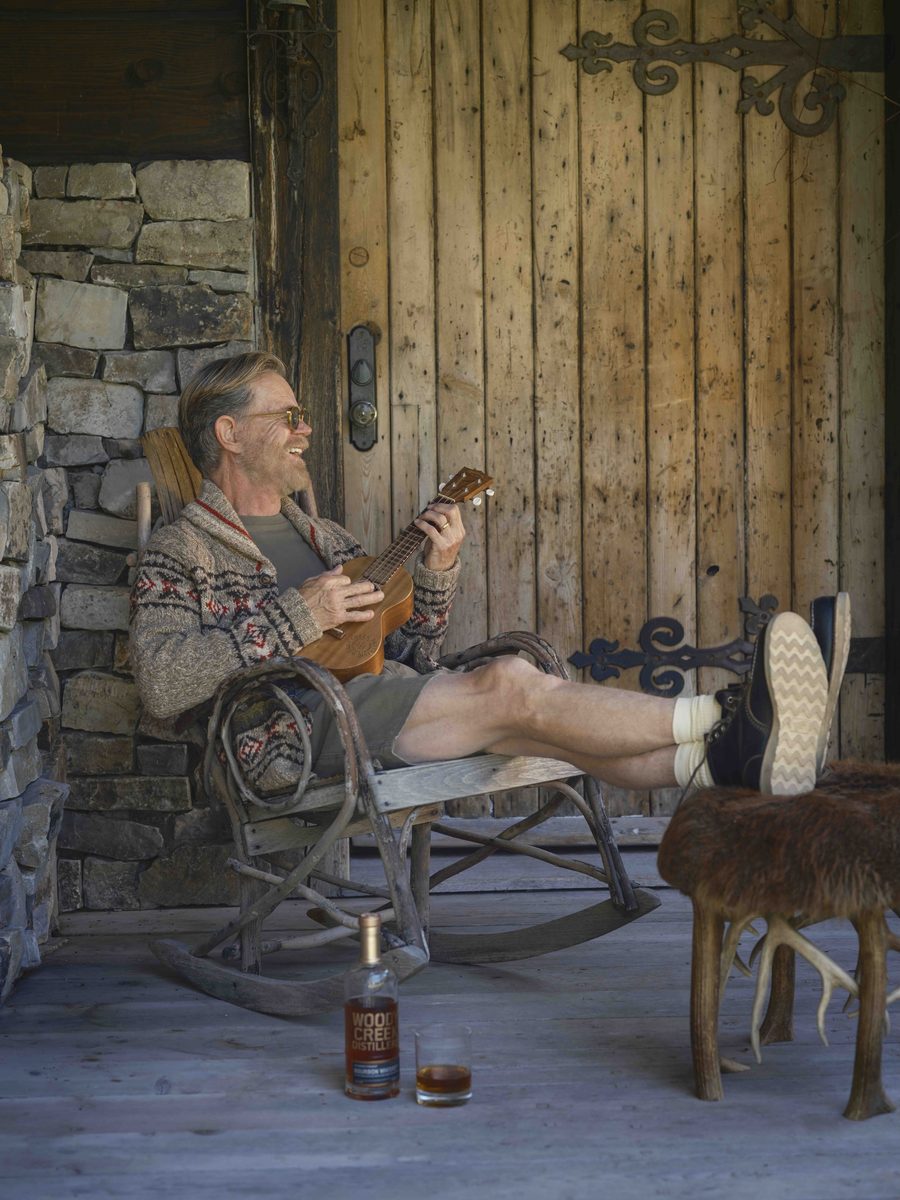 man in porch chair with ukelele