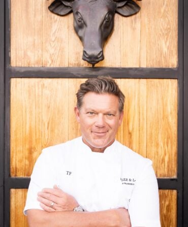 A chef under a sculpture of a bull head