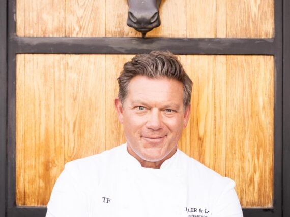 A chef under a sculpture of a bull head