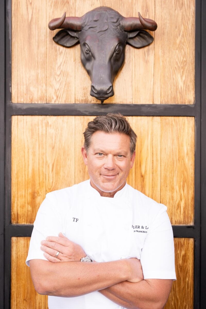 A chef under a sculpture of a bull head