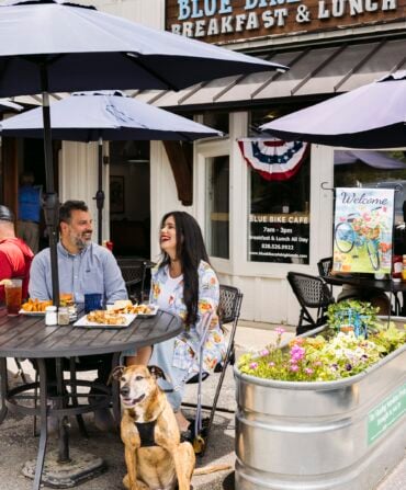 A couple and dog outside a cafe