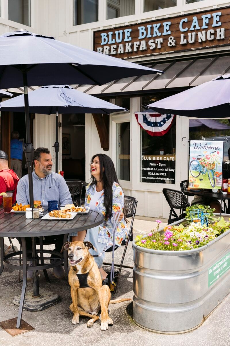 A couple and dog outside a cafe