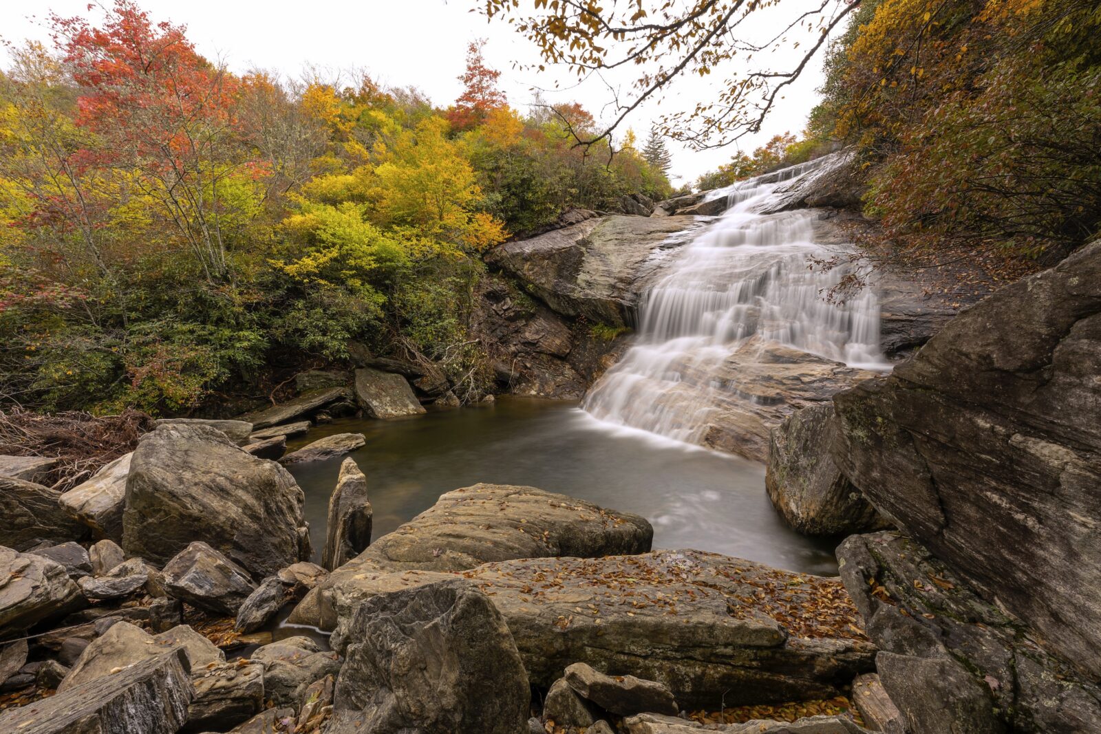 A waterfall with fall leaves