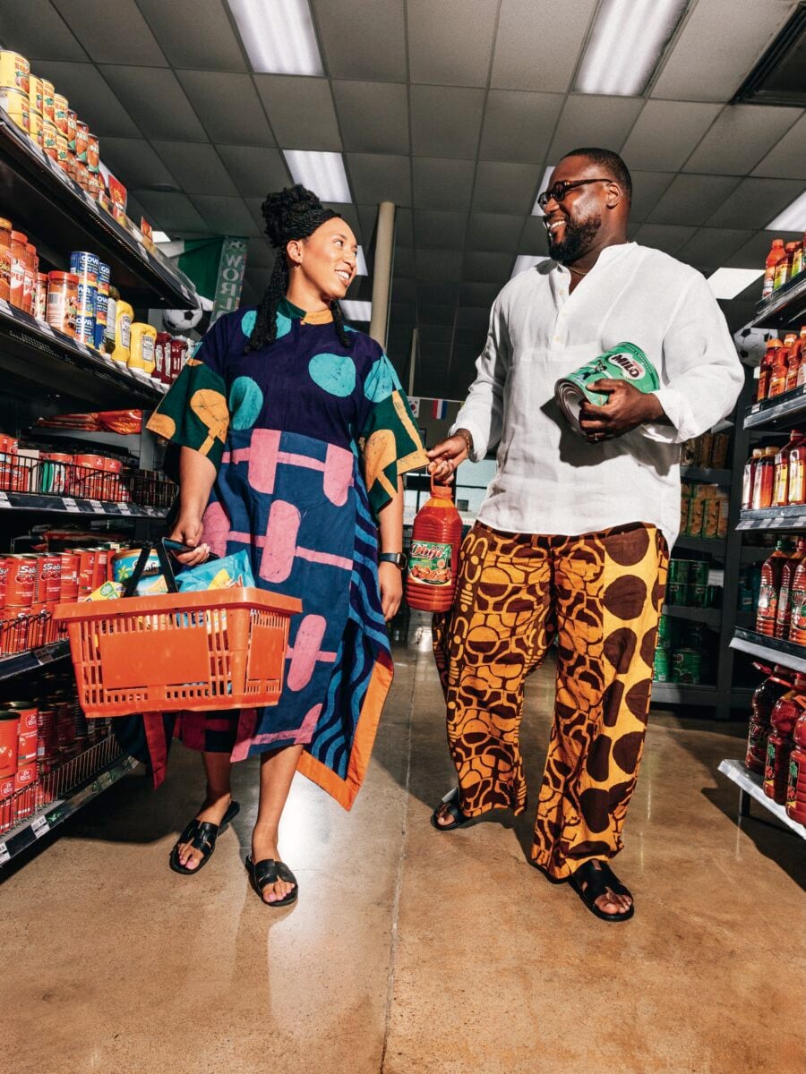 A man and woman walk through a market