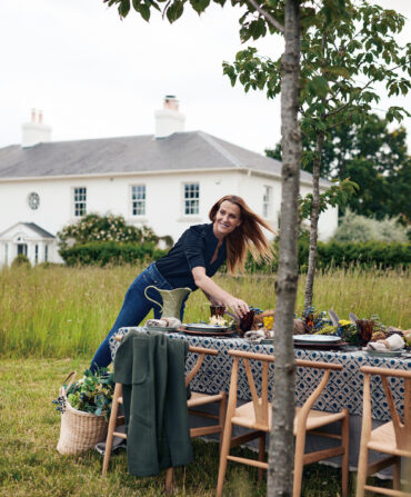 A woman sets a table outside