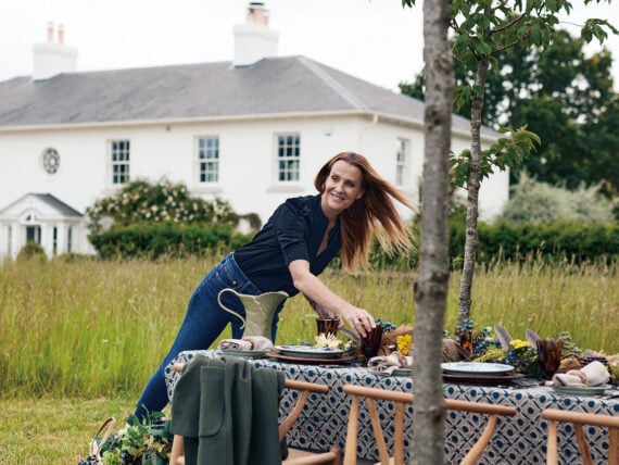 A woman sets a table outside