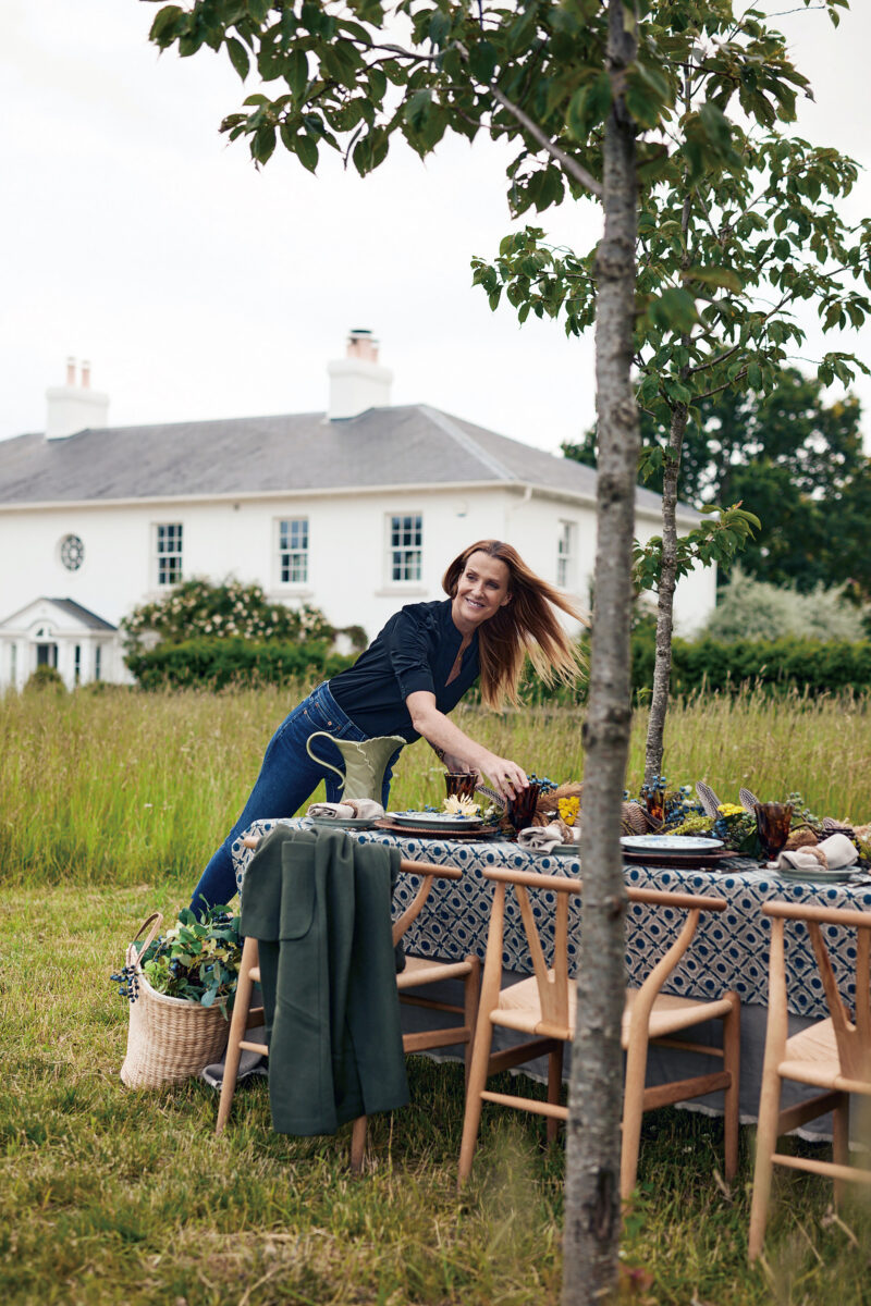 A woman sets a table outside