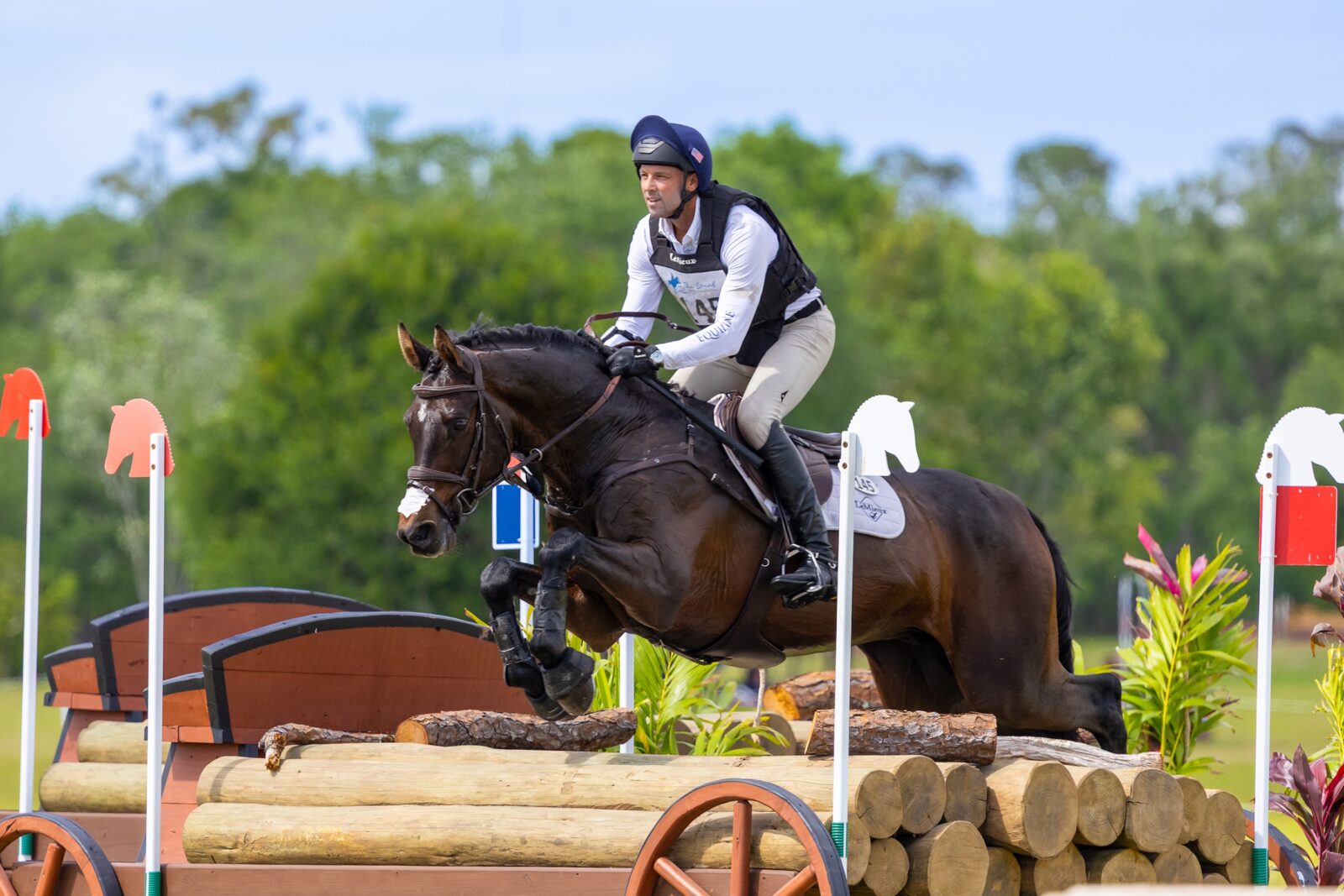 A man jumping a horse over a fence