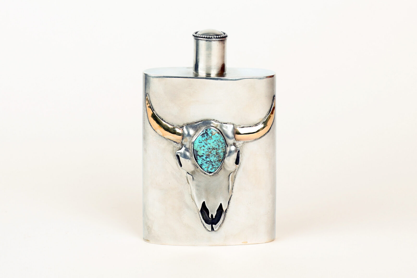 A silver and turquoise gem flask with a bull head