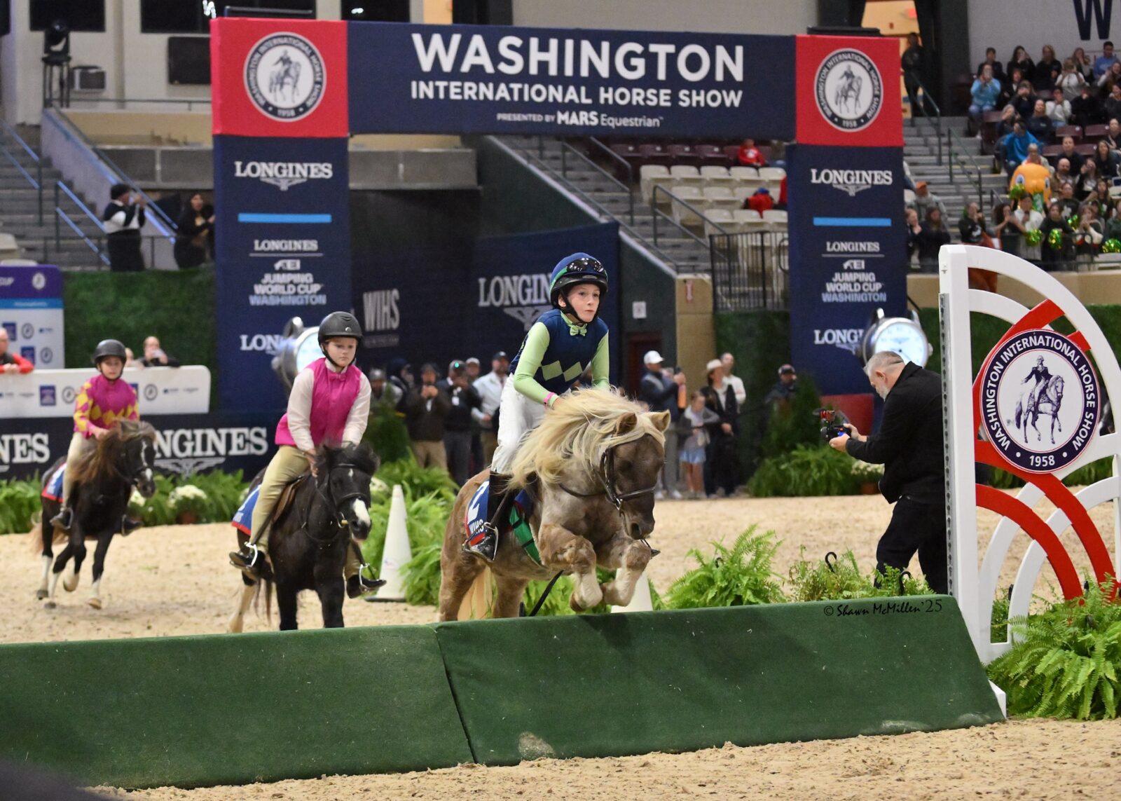 Kids ride ponies over jumps